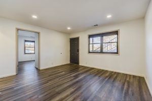 Living room with plank floors and windows.